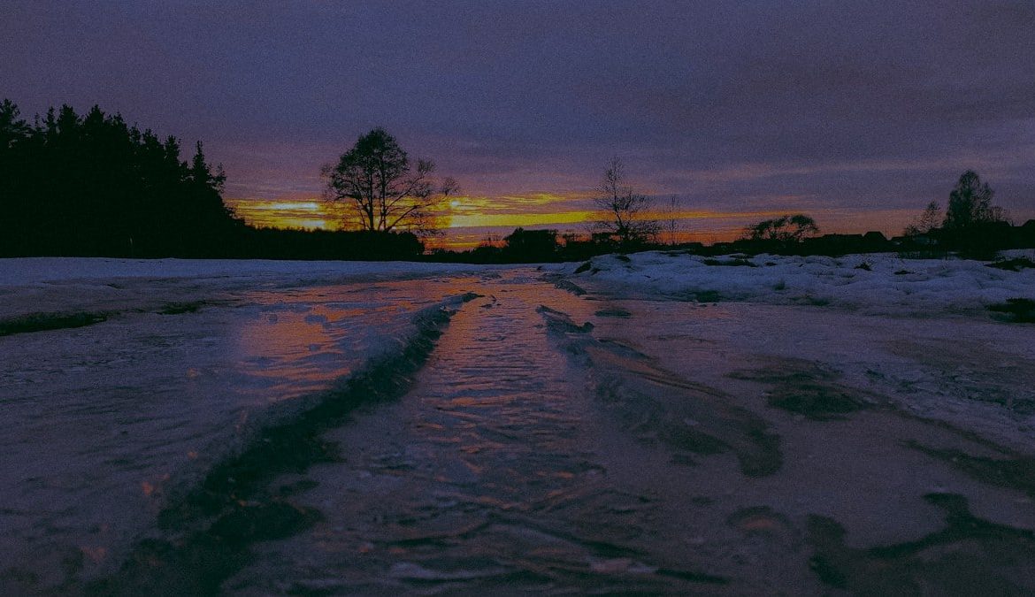 Sunset over a frozen landscape with trees